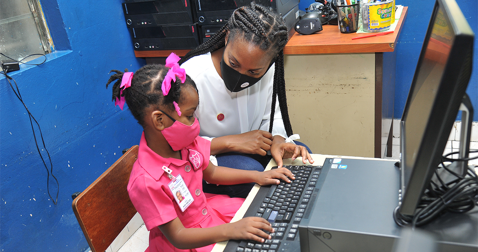 Regina Owen (right), Programme Administrator with the VM Foundation assists little Reniah Edite of the One Way Early Childhood Institution in using a computer donated to the school through Victoria Mutual Group’s ‘Refurbish for Change’ initiative. The school was one of several institutions which received over 130 computers, which were refurbished for use by the VM’s Group Information Communication Technology Unit.